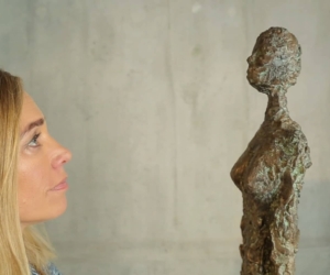 Heidi Sand schaut eine Skulptur an