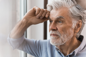 Mann in Gedanken lehnt an Fensterscheibe Mann in Gedanken lehnt an Fensterscheibe