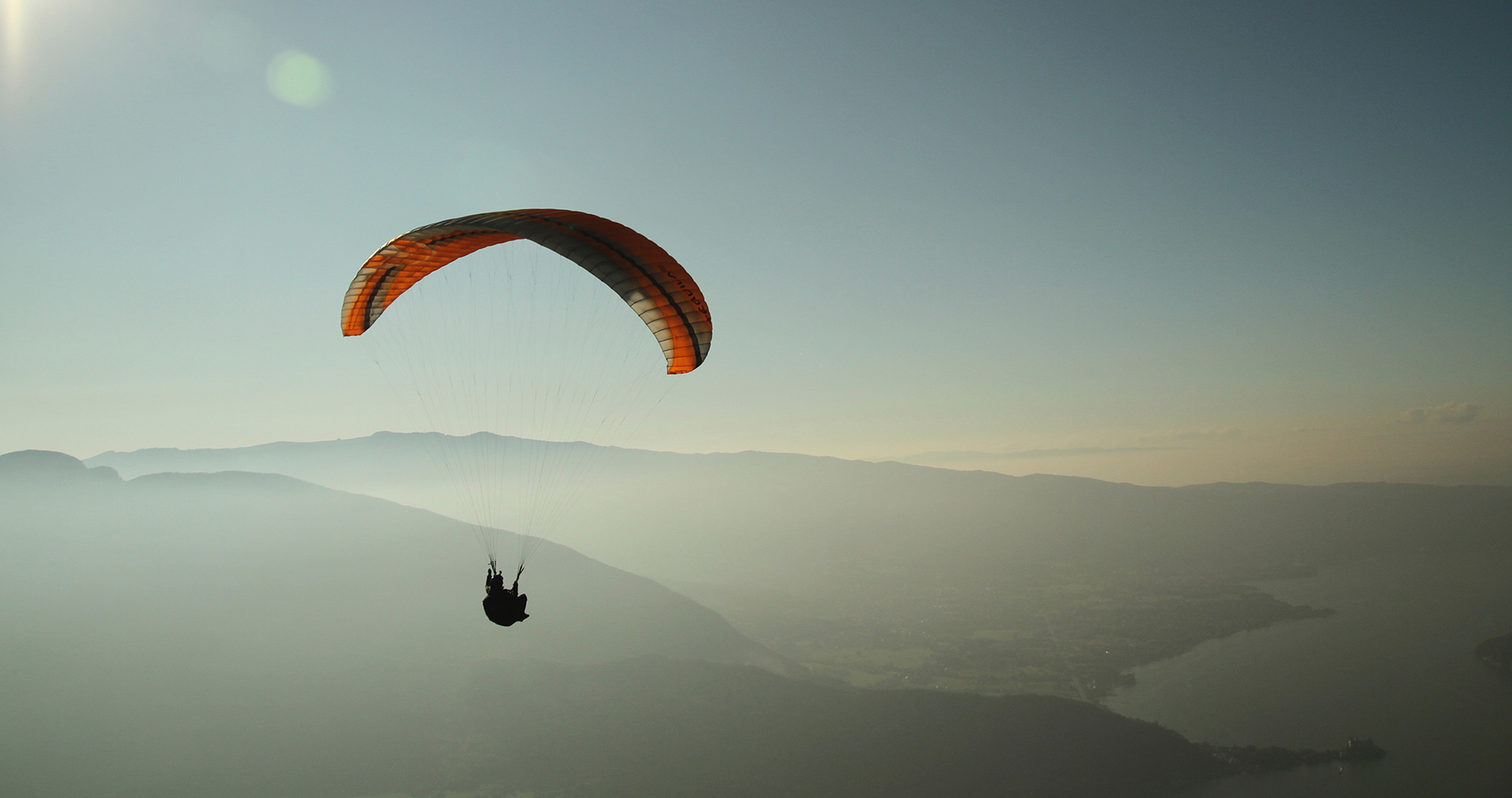 Gleitschirmflieger fliegt hoch, vor dem Hintergrund von Bergen