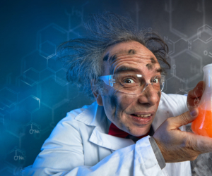 Verrückter Professor hält ein Laborglas mit farbiger, dampfender Flüssigkeit in der Hand