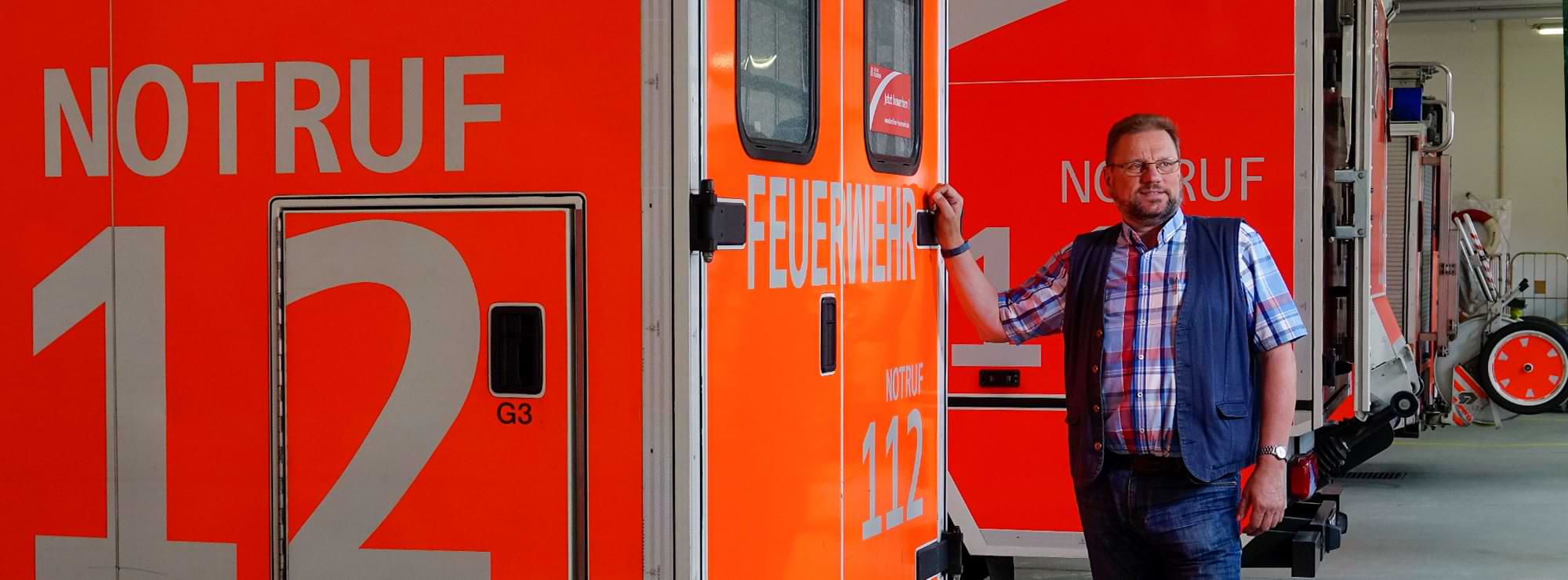 Peter-Klaus Rambow steht an einem Feuerwehrfahrzeug