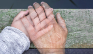 Halbtransparente Hand eines Mannes auf der Hand einer Frau als Zeichen für Verlust