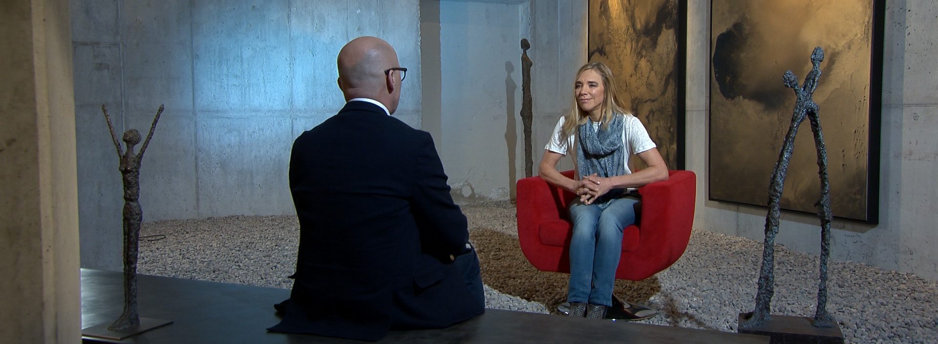 Heidi Sand sitzt in einer Kunstgalerie im Roten Sessel für ein Interview