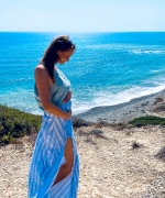 Schwangere Frau am Strand hält ihren Bauch