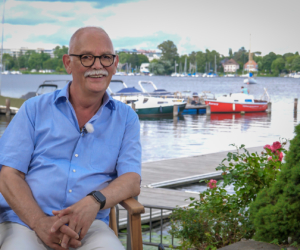 Klaus Eisenbeisz vor einem Segelboothafen, im Hintergrund Schiffe und die Havel