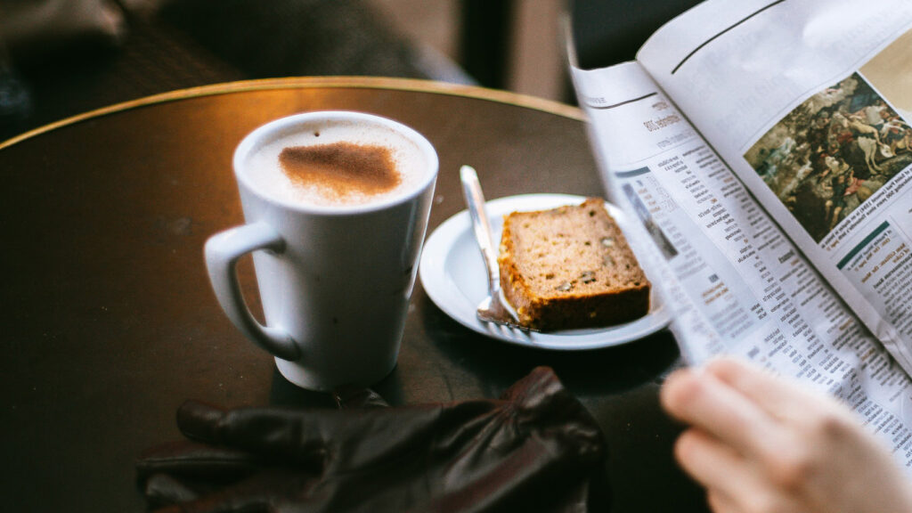 Kaffeetasse auf Tisch mit Zeitung