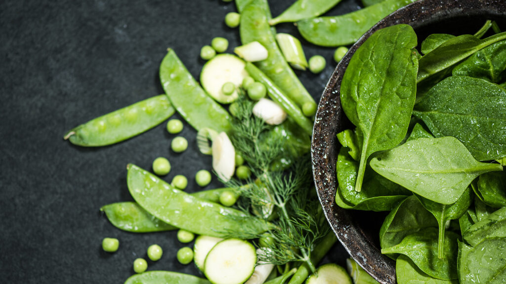 sauberes Essen und gesunde Ernährung grünes Gemüse auf dunklem Schiefer