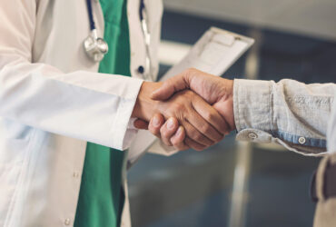 Arzt und Patient geben sich die Hand