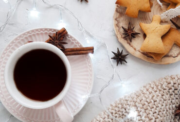 weihnachtlich gedeckter Kaffeetisch mit Dekoration, weißer Decke, Plätzchen und Anis und Zimt
